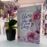 Devocional Un año con Dios exhibido junto a una orquídea en una librería cristiana – imagen 4